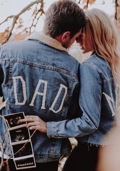 a man and woman embracing each other with the words dad written on their denim jacket