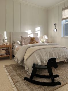 a bedroom with a rocking horse bed in the middle and a teddy bear sitting on top of it