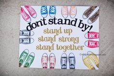 a sign that says, don't stand by stand up and strong together with colorful shoes