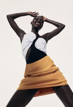 a woman in a black and white top is posing with her hands on her head