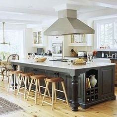 a large kitchen with an island in the middle and lots of stools around it