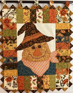 a patchwork quilt with a scarecrow wearing a hat on it's face