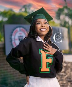 a woman in a graduation cap and gown posing for a photo with her hands on her chest