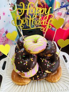 a pile of doughnuts sitting on top of each other with happy birthday written on them