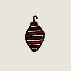 an embroidered ornament hanging from a string on a white background with red and black stripes