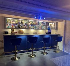 a bar with three blue chairs in front of it