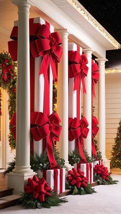 red and white christmas decorations on pillars in front of a house with lit up trees