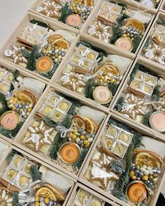 several boxes filled with assorted cookies and candies on top of a white table