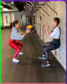 two women are playing with a ball in an indoor gym