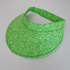 a green bandana on a white background with swirls in the middle and one knot at the top