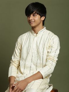 Yuva By VASTRAMAY Boys Cream Embroidered Mirror Work Kurta Pyjama Set This cream colored kurta pyjama set features beautiful vertical mirror embroidery, adding a touch of elegance and sophistication. The kurta has a straight cut, mandarin collar, and two pockets with mirror work detail. The set is made from poly georgette fabric for a comfortable feel. Key Features Cream colored with vertical mirror embroidery Straight kurta with mandarin collar Two pockets with mirror work detail Cream colored Cream Long Sleeve Set With Cutdana, Diwali Long Sleeve Sets With Chikankari Embroidery, Diwali Long Sleeve Chikankari Embroidery Sets, Cotton Long Sleeve Sherwani For Navratri, Off White Long Sleeve Kurta With Cutdana, Cream Long Sleeve Kurta With Cutdana, Off White Long Sleeve Traditional Wear For Diwali, Long Sleeve Kurta With Chikankari Embroidery For Diwali, Bollywood Cotton Long Sleeve Sherwani