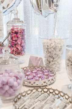 a table topped with lots of candies and other items on top of a white table