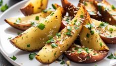 baked potato wedges with parmesan cheese and chives on a white plate