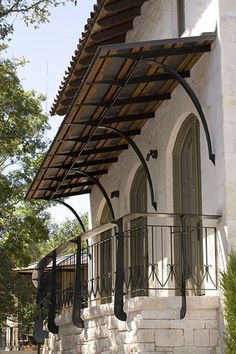 a white house with an awning over it's balcony