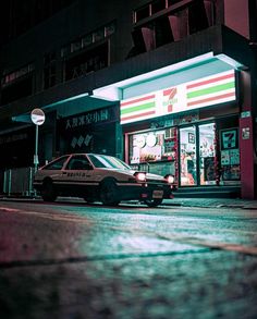 a police car is parked in front of a convenience store at night with its lights on