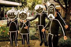 a group of people with paper cutouts on their faces standing in front of trees