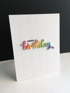 a card with the words happy birthday written in multicolored letters on white paper