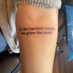 a person with a tattoo that says in the hardest times, we grow the most