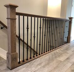 a wooden banister with black iron handrails in a home's entryway