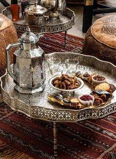 an ornate tray with desserts on it sits on a rug in the middle of a room