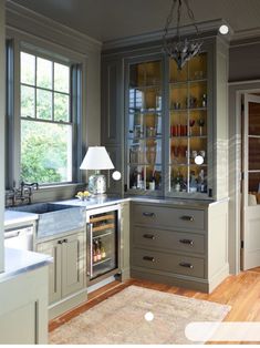 a kitchen with gray cabinets and wooden floors