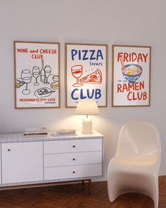 a white chair sitting next to a table with two pictures on the wall above it