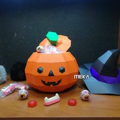 an orange pumpkin sitting on top of a wooden table next to other halloween decorations and toys