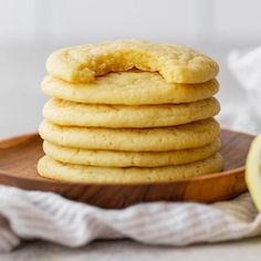 a stack of cookies sitting on top of a wooden plate next to a lemon slice