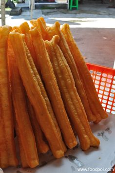 a pile of cheetos sitting on top of a table next to a red basket