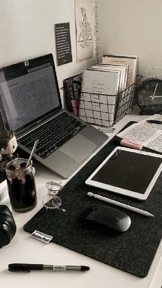 a laptop computer sitting on top of a desk next to a mouse and other items