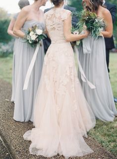 three bridesmaids standing in front of each other with their dresses pulled back and holding bouquets