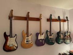 four guitars are hanging on the wall