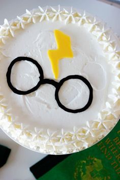 a harry potter cake with white frosting and yellow lightning bolt on top