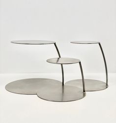 three round metal tables sitting on top of each other