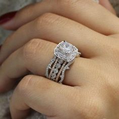 a woman's hand with a ring on her finger and two diamonds in the middle