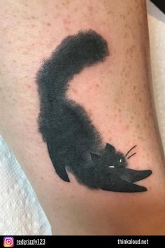 a black cat is on the leg of a woman's legs, and it looks like she has her tail curled up