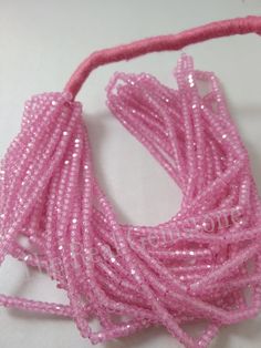 pink beads are lined up on a white surface