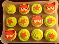 cupcakes with green frosting and orange icing decorated as animals, stars and masks