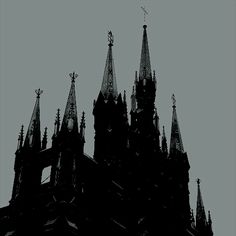 the silhouette of an old church with steeples and spires on a cloudy day