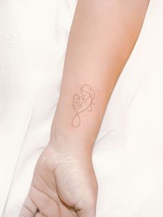 a woman's arm with a small tattoo on it