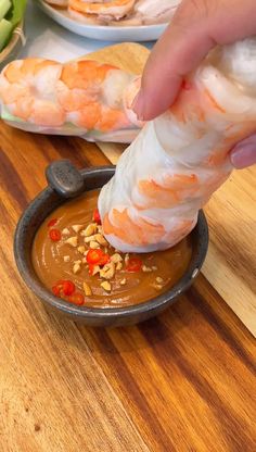 a person dipping some kind of food into a bowl