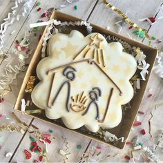 a decorated cookie in a box with confetti around it