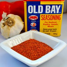 an old bay seasoning in a bowl next to garlic