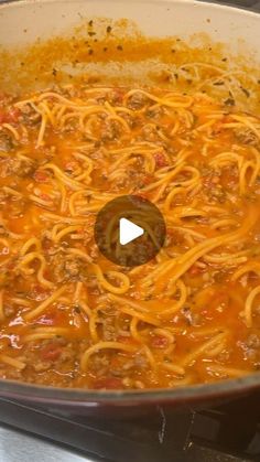 a large pot filled with spaghetti and sauce on top of a stove burner oven