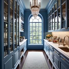 a kitchen with blue cabinets and a chandelier hanging from the ceiling