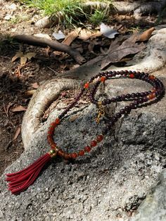 "Introducing our NEW COLLECTION of Customizable Suede Tassel Crystal Mala Beads! This premium 108 bead mala is made of CARNELIAN & GARNET beads and is accented with gold-tone spacers which are lead-free, iron-free. Length: 36\". The 3\" suede tassel is shown in RED, but may be customized to any other color of your liking. Simply select your desired color from the listing's drop down menu. A key charm is located on the back of the piece, which lands directly under the pineal gland. This symbo Red Beaded Necklace With 108 Beads For Meditation, Spiritual Tassel Necklace With 108 Round Beads, Red Beaded Mala For Rituals, Bohemian Red Mala With Round Beads, Adjustable Red Mala With 108 Beads, Red Beaded Bohemian Mala, Red Bohemian Beaded Mala, Red Hand-strung Spiritual Mala, Yoga Necklace