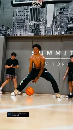 young men playing basketball in an indoor gym with the city skyline and skyscrapers behind them