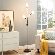 a living room scene with focus on the floor lamp and couch in the foreground