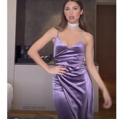 a woman in a purple dress posing for the camera