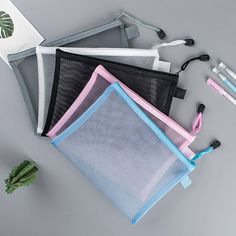 three zippered pouches sitting on top of each other next to a plant and scissors